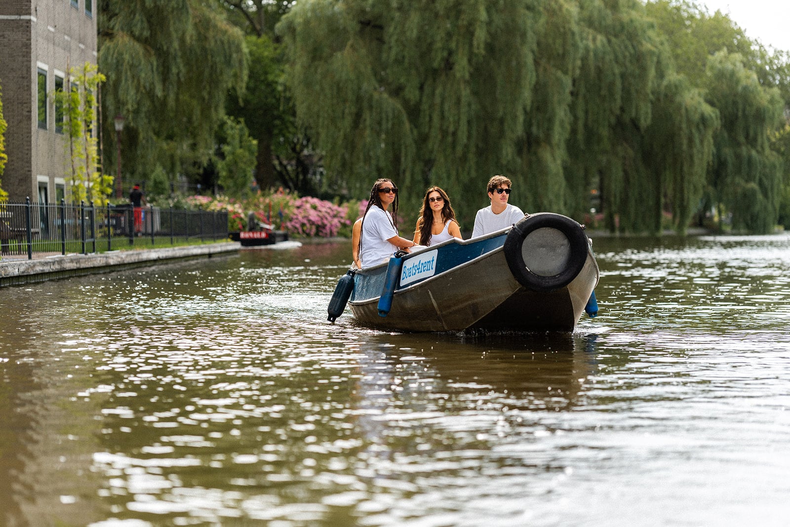 Three people sail across the water